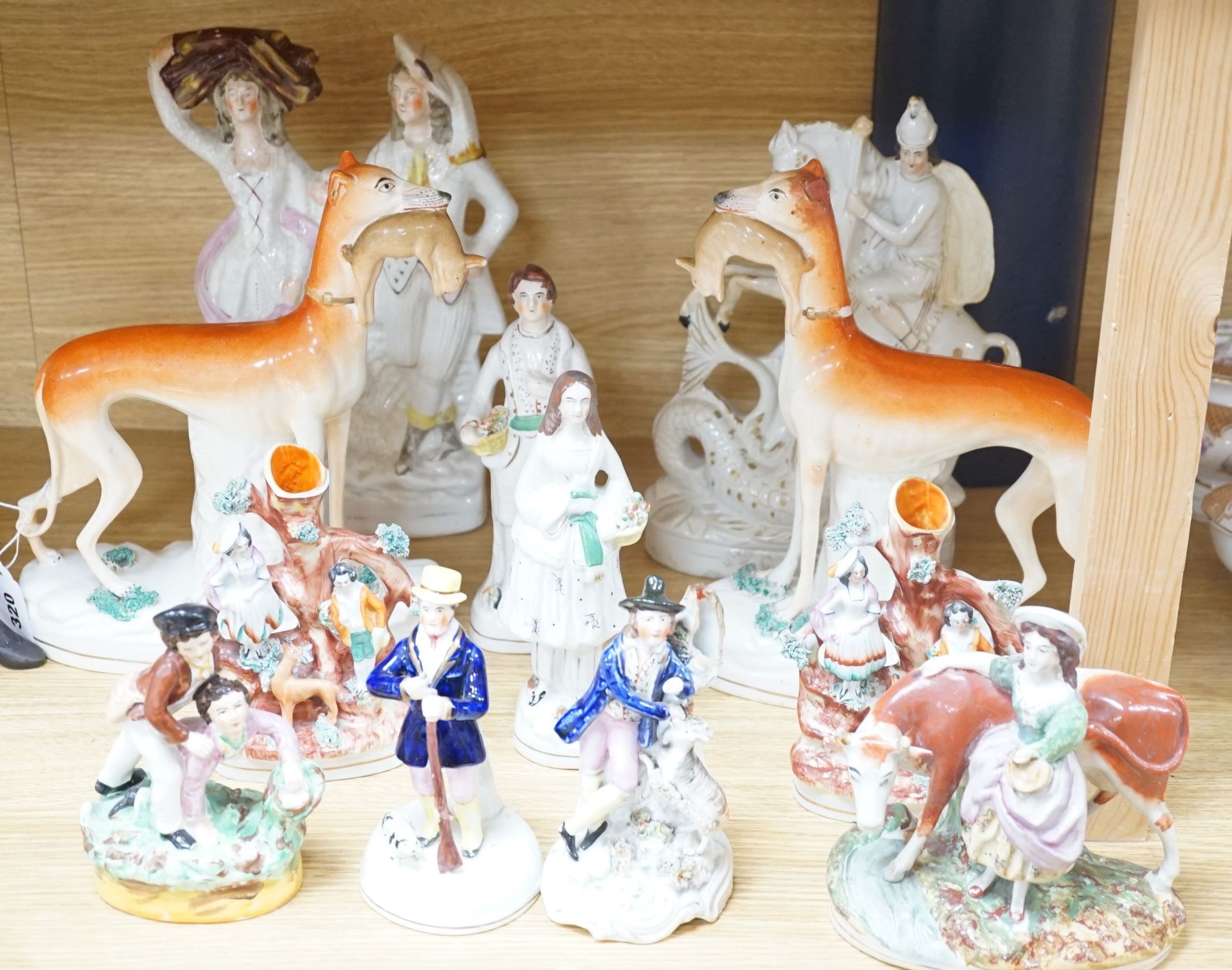 A collection of twelve Victorian Staffordshire flat back figures and groups, tallest 31 cms high.